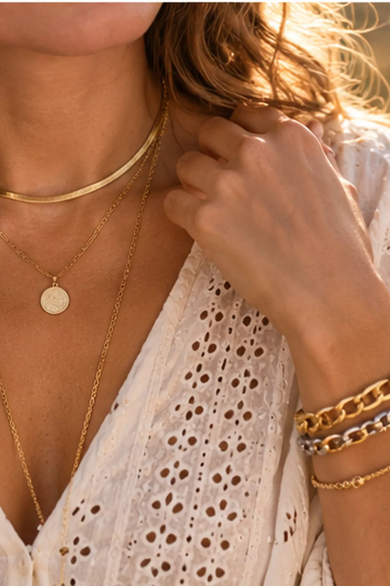 Boho-Schmuck: drei Goldketten in verschiedenen Längen mit Kreis-Anhänger und gemischtem Armband-Stack