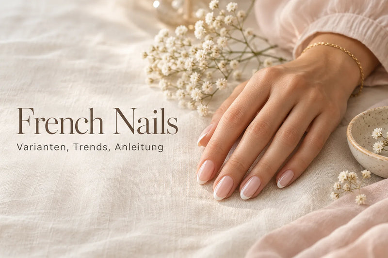 French Nails mit milchweißer Spitze an gepflegter Hand mit feinem Goldarmband auf cremefarbenem Leinen